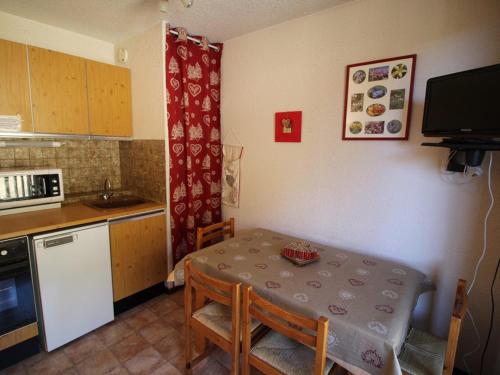 une cuisine avec une table et une petite cuisine avec une table et des chaises dans l'établissement Appartement 2 pièces, 300m des pistes, parking, animaux admis - Auris en Oisans - FR-1-297-44, à Auris