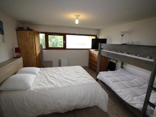 ein Schlafzimmer mit einem weißen Bett und einem Fenster in der Unterkunft Appartement Auris, 2 pièces, 8 personnes - FR-1-297-73 in Auris