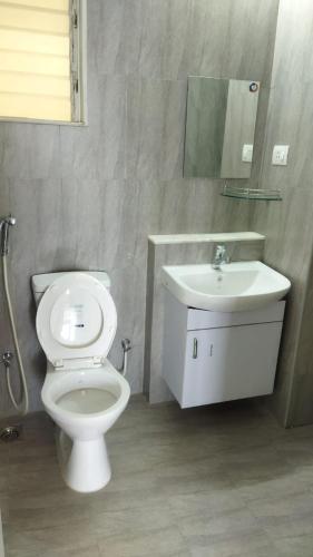 a bathroom with a toilet and a sink at TATA Rio De Goa ,Goodstay 2 BHK Apartment With Pool ,6km from Airport ,201 in Vasco Da Gama