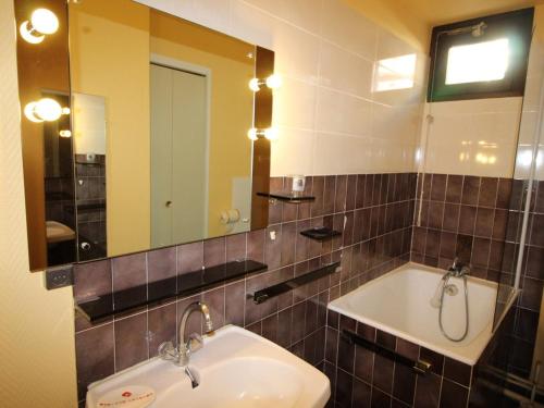 une salle de bain avec un lavabo et un miroir dans l'établissement Studio cabine rénové 4 pers au pied des pistes, proche commerces, ESF et luge - FR-1-297-117, à Auris
