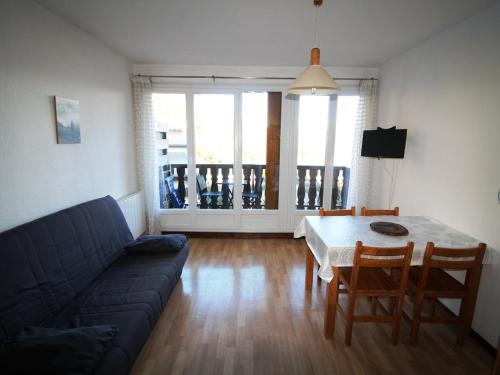 un salon avec un canapé, une table et des chaises dans l'établissement Studio cabine 4 pers au pied des pistes avec parking – Auris en Oisans - FR-1-297-62, à Auris