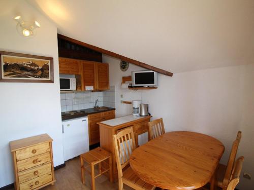 uma cozinha com uma mesa de madeira, uma mesa e cadeiras em Appartement Auris, 1 pièce, 4 personnes - FR-1-297-60 em Auris