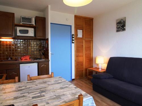 Il comprend une cuisine et un salon avec une porte bleue. dans l'établissement Studio cabine 4 pers au pied des pistes avec parking – Auris en Oisans - FR-1-297-62, à Auris