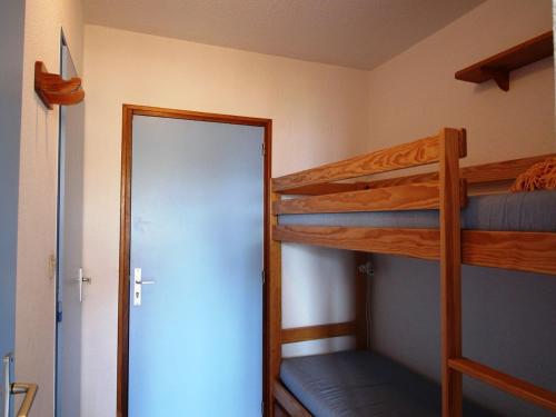 - une chambre avec 2 lits superposés et une porte dans l'établissement Studio cabine 4 pers au pied des pistes avec parking – Auris en Oisans - FR-1-297-62, à Auris