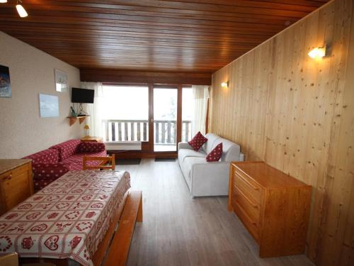 a room with a living room with a couch and a table at Appartement Auris, 1 pièce, 4 personnes - FR-1-297-68 in Auris