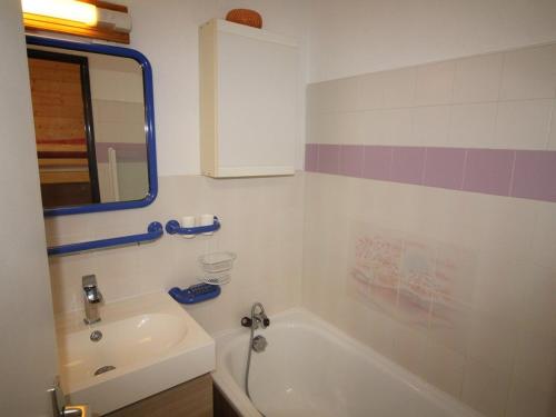 a bathroom with a tub and a sink and a mirror at Appartement Auris, 1 pièce, 4 personnes - FR-1-297-61 in Auris