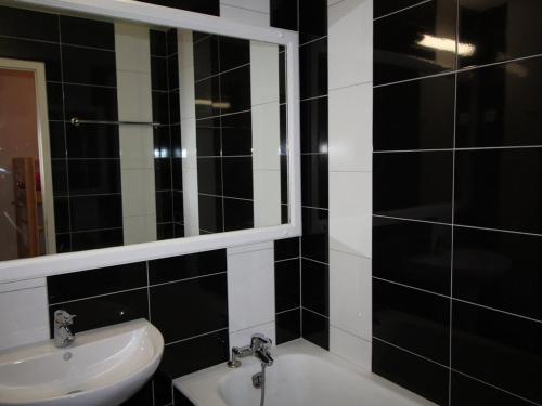 - une salle de bains en noir et blanc avec lavabo et miroir dans l'établissement Appartement Auris, 2 pièces, 8 personnes - FR-1-297-101, à Auris