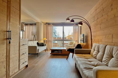 Modern Apt At The Foot Of The Slopes In Megève في ميجيف: غرفة معيشة مع أريكة وطاولة