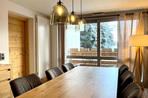 une salle à manger avec une grande table et des chaises en bois dans l'établissement Modern Apt At The Foot Of The Slopes In Megève, à Megève