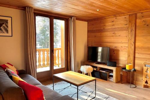 sala de estar con sofá y TV en Chic And Cosy Apt With Balcony In Megeve en Megève