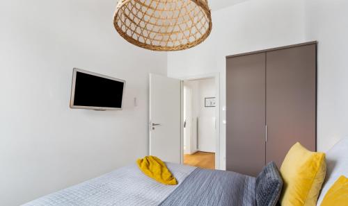 a bedroom with a bed and a flat screen tv at Penthouse Hygge Meerblick am Strand in Olpenitz