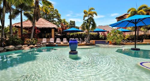 uma piscina com um vaso azul na água em Luxury Living In The Heart Of Town, King Bed, 2 Pools, Free WIFI And Undercover Parking em Port Douglas
