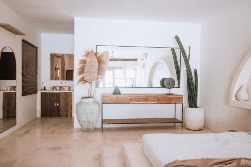 a bedroom with a mirror and a table with plants at Hotel Sages in Canggu