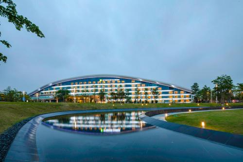 a building with a river in front of it at Wyndham Garden Jinjiang in Jinjiang