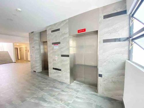 a lobby with a elevator in a building at Urban Serviced Apartment in Bandar Penawar
