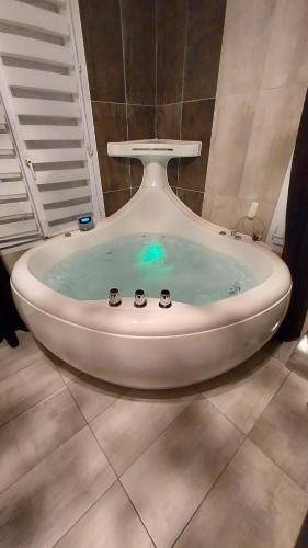 une baignoire remplie d'eau bleue dans une salle de bain dans l'établissement Appt 4P, parking, Disney direct, Vallée Village, à Serris
