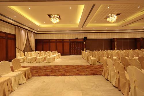 an empty banquet hall with white chairs and tables at Hotel Cenneys Gateway in Salem