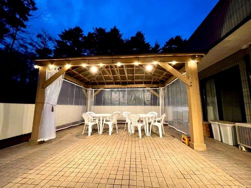 a patio with a table and chairs and lights at Garden Villa in Fujiyoshida
