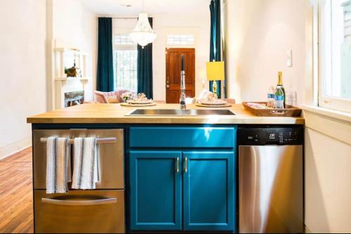 紐奧良的住宿－Elegant Renovated House With Relaxing Courtyard，蓝色的厨房配有水槽和洗碗机