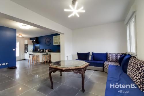 sala de estar con sofá azul y mesa en Les Myrtilles - Maison 6 personnes à Limoges en Limoges