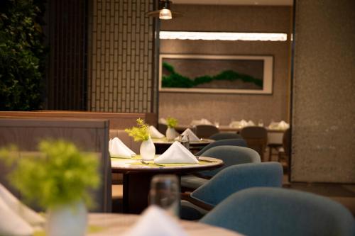 a dining room with tables and chairs and a painting at Wyndham Garden Jinjiang in Jinjiang