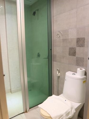 a bathroom with a toilet and a glass shower at Swana Bangkok Hotel in Bangkok
