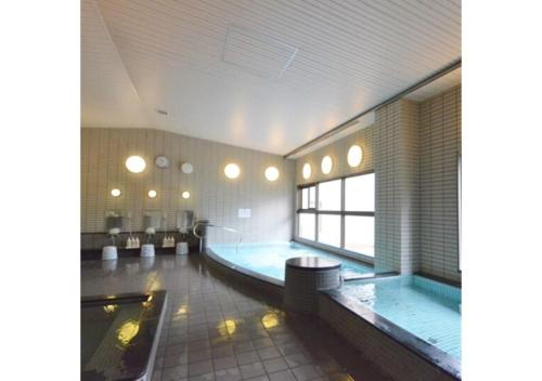 a large bathroom with a swimming pool in a building at Isawa no sato / Vacation STAY 61566 in Shiso