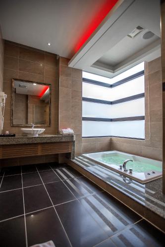 a bathroom with a tub and a sink at One + One Motel in Longtan