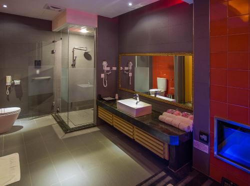 a bathroom with a sink and a shower and a mirror at One + One Motel in Longtan
