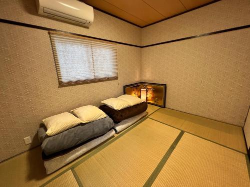 two beds sitting in a room with a window at Old modern house in Nara Second in Nara