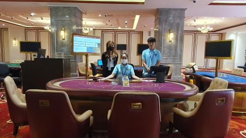 two people sitting at a poker table in a casino at Legend Hotel and Resort in Sihanoukville