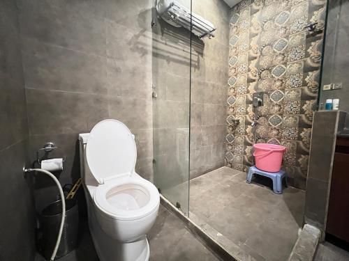 a bathroom with a toilet and a glass shower at Hotel White Orchid Dalhausie in Dalhousie