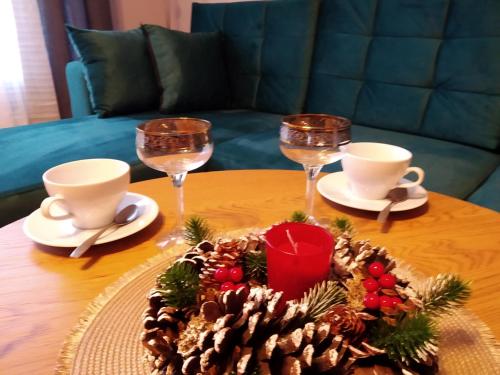 - une table avec des verres à vin et une pièce maîtresse de Noël dans l'établissement Baltijos 12b Apartamentai, à Klaipėda