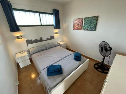 a bedroom with a bed with blue towels on it at Las Torres Del Castillo-120 Palms in Costa de Antigua