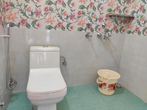 a bathroom with a toilet and a flower wallpaper at Anandam Home Stay in Rishīkesh