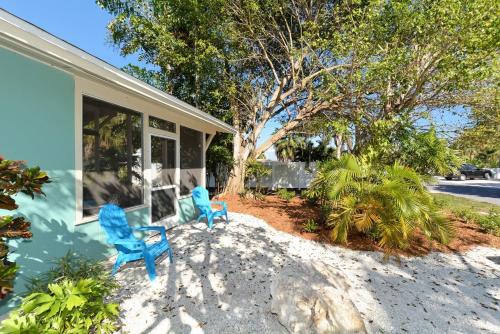 two blue chairs sitting outside of a house at Minnow 2 Villa in Anna Maria