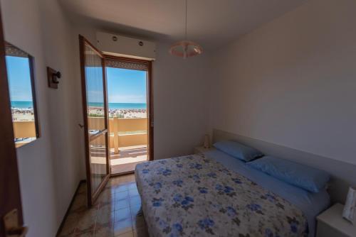 - une chambre avec un lit et une vue sur l'océan dans l'établissement Condominio Carina Sud, à Bibione