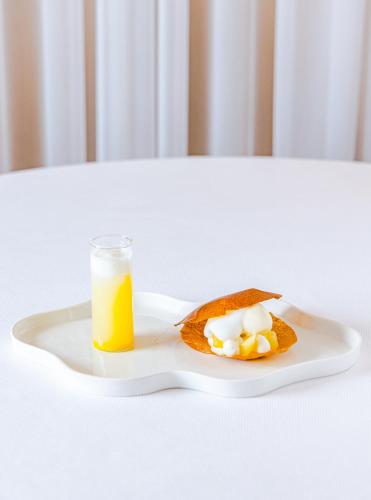 a plate of food with a glass of orange juice at Hostellerie Du Chapeau Rouge in Dijon