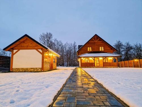 a house in the snow with a stone pathway at Holiday home Marta in nature with jacuzzi in Gospić