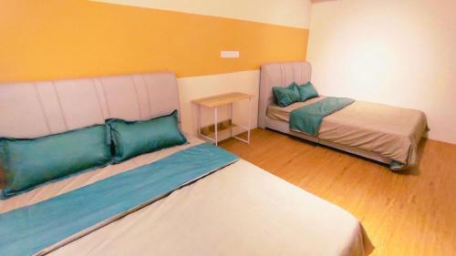 um pequeno quarto com duas camas e uma mesa em Bandar Putra Kulai 6BR 14pax Dormitory Style House em Kulai