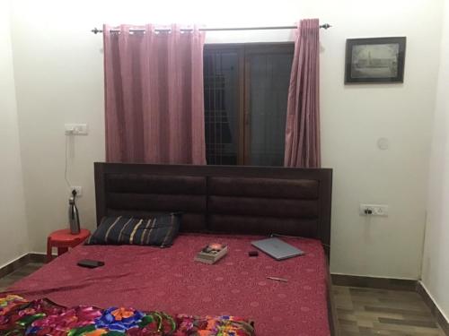 ein Schlafzimmer mit einem Bett und einem Laptop darauf in der Unterkunft PRITHVI FOREST HOMESTAY in Dehradun