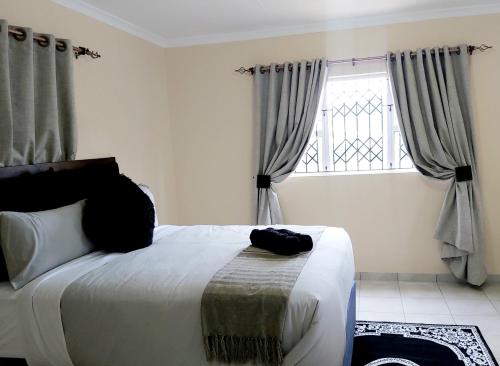 a bedroom with a large bed and a window at Ezweni Lodge in Inanda