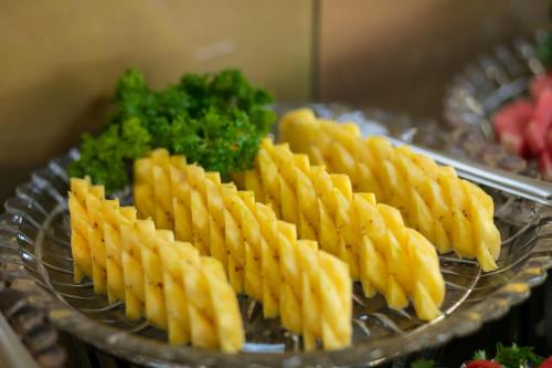 a plate of food with french fries and broccoli at Hanoi L'Heritage Hotel & Gym - Spa in Hanoi