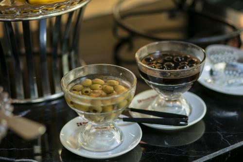 two glass vases filled with olives on a table at Hanoi L'Heritage Hotel & Gym - Spa in Hanoi
