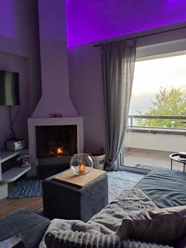 a living room with a fireplace and a room with a couch at Vrachos Suites in Aigio