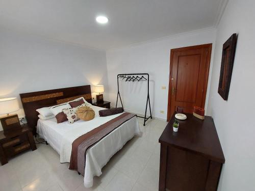Neda的住宿－Acogedora Casa de campo- BAJO con finca-，一间卧室配有一张大床和一张木桌