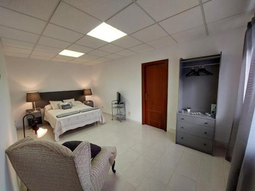 a bedroom with a bed and a dresser in it at Acogedora Casa de campo- BAJO con finca- in Neda