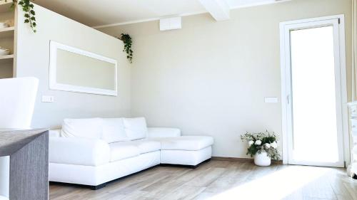 Sala de estar blanca con sofá blanco en Falconetta Luxury House en Portoferraio