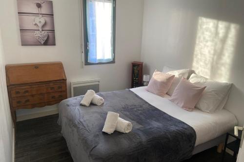 a bedroom with a bed with two towels on it at Very nice T3 at 3 min from the beach St Enogat in Dinard