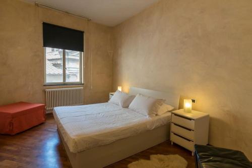 a bedroom with a white bed and a window at Fillungo180 in Lucca